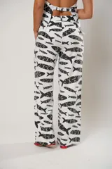 Pantalón palazzo blanco con estampado de peces negros.