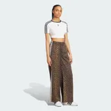 Pantalón Adidas Originals de pierna ancha, confeccionado en satén con estampado animal print de leopardo. Cuenta con cintura elástica, las clásicas tres tiras blancas en los laterales y el logo del trifolio bordado en el frente.
