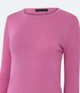 Suéter de punto color rosado, con cuello barco, mangas largas y puños con botones decorativos. El dobladillo también es acanalado.