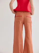 Pantalon de lino de corte recto y tiro medio, color terracota con vivos laterales en color rojo. Cuenta con bolsillos laterales.