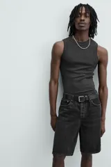 Bermuda de denim de algodón, color verde claro lavado, de corte recto y tiro medio. Presenta cinco bolsillos y cierre frontal con cremallera y botón.