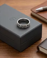 Anillo de plata 925 con diseño empavonado y banda central giratoria con patrón de eslabones entrelazados.