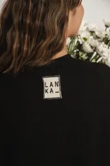 Remerón negro de mangas cortas con tajos a los costados.