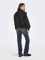 Campera de efecto cuero con cierre frontal, cuello camisero, mangas largas abullonadas con puños acanalados y diseño de paneles verticales.
