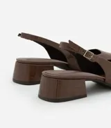 Zapato de tacón con textura croco, color blanco, modelo slingback, con puntera fina, taco bloque mediano y cierre por hebilla.