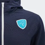 Chaqueta deportiva con capucha y cierre frontal, color azul marino, con patrón geométrico en relieve en el cuerpo. Presenta detalles en blanco en los laterales y puños y tobillos ajustados. Lleva el logo de Macron y el escudo de Uruguay Rugby en el pecho.