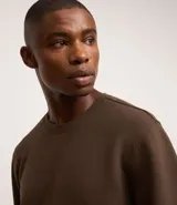 Buzo deportivo color verde claro, de manga larga y cuello redondo. Confeccionado en tejido de poliéster, viscosa y elastano.