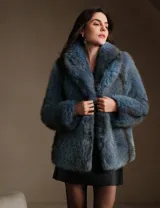 Tapado de piel sintética en color azul, con cuello amplio y silueta relajada de largo medio.