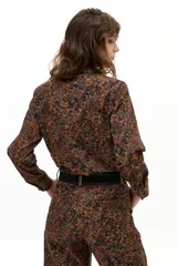 Pantalón de pana con corte barrel, tiro medio y estampado tipo tapiz en tonos marrones y negros. Cuenta con cierre frontal, pasacintos y bolsillos laterales y traseros.