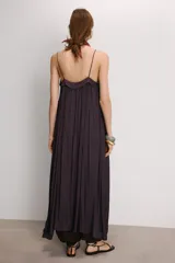 Vestido midi color morado oscuro, confeccionado en tejido satinado con efecto plisado o arrugado. Presenta escote en pico y tirantes finos ajustables. El calce es fluido y holgado.