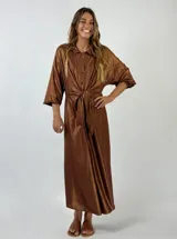 Vestido midi plateado brillante, tipo camisa, con cuello clásico, mangas 3/4 y lazo en la cintura.