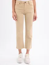 Jean de corte mini flare en color beige, con diseño de tiro medio y largo hasta el tobillo, confeccionado en tejido de algodón con elastano.