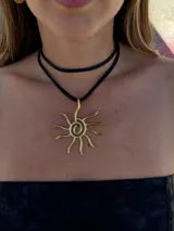 Collar con cordón ajustable color beige y dije de sol plateado.