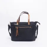 Cartera tipo bolso de color negro con detalles en color suela. Cuenta con doble asa de mano, correa ajustable y extraíble, bolsillo frontal con cierre y herrajes metálicos dorados.