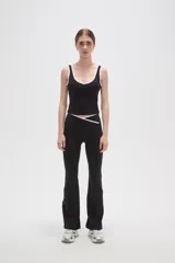 Musculosa deportiva de poliamida, color negro con detalles de ribetes blancos en el cuello y sisas. Presenta un diseño ajustado al cuerpo con escote profundo.