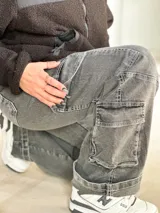 Jean cargo de mujer color gris desgastado, de corte recto y tiro alto, con múltiples bolsillos funcionales en los laterales y diseño utilitario.