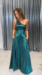 Vestido largo de fiesta color verde esmeralda con acabado metalizado, diseño de un solo hombro y falda con tajo lateral y bolsillos.
