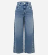 Pantalón wide leg de tiro bajo confeccionado en jean de algodón, con diseño amplio y aplicación de tachas y ojalillos metálicos a lo largo de los laterales.