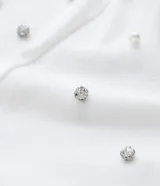 Blusa de algodón color blanco, con escote en V, manga corta y detalle de aplicación de strass en los hombros.