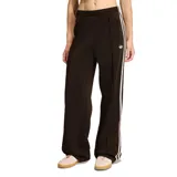 Pantalon deportivo Adidas de corte holgado, color marrón con las icónicas tres tiras laterales en tono claro y logo del trébol bordado en la pierna. Cuenta con cintura elástica y bolsillos laterales con cierre.