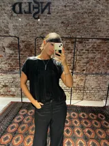 Blusa de manga corta con acabado de lurex, cuello redondo y corte holgado.