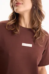 Remera de algodón amarilla de manga corta, con corte suelto y pequeño aplique rectangular en el pecho.