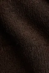 Chaleco de punto fino con lana, de corte holgado, cuello redondo y aberturas laterales pronunciadas. Presenta remates acanalados en el cuello, las sisas y el bajo.