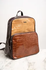 Mochila marrón con estampado de piel de cocodrilo, con cierre superior y bolsillo frontal con cierre.