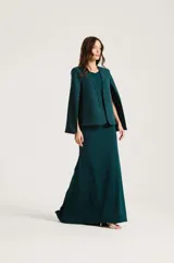 Vestido midi verde oscuro de corte al cuerpo, sin mangas, con aberturas laterales en la cintura decoradas con aplicaciones bordadas plateadas en forma de hojas.
