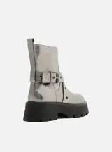 Bota corta plateada con hebilla y suela track negra.