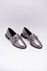 Mocasines de cuero en tono bronce metalizado, con detalle de aplique metálico dorado en el empeine y taco cuadrado bajo de madera.