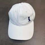 Gorra de visera curva confeccionada en tejido de jean color blanco, con logo bordado en color azul marino en el panel frontal.