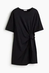 Vestido corto negro de punto con cuello redondo, mangas cortas y detalle de nudo en un lateral.