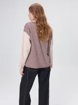 Remera de manga larga con diseño a rayas horizontales en tonos celestes y blancos en el cuerpo, y mangas a rayas azul marino y blancas. Presenta cuello redondo en color azul marino, logo bordado en el pecho y calce holgado.