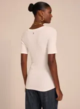 Remera blanca de tejido de punto con corte ajustado, escote en V, mangas cortas y acabado pespunteado.