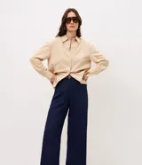 Pantalón de sastrería color bordó, de corte recto y largo midi, con cintura con pasadores y cierre frontal. Incluye un cinturón fino de poliuretano con hebilla metálica.