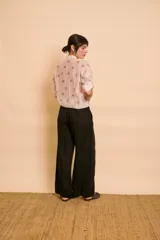 Pantalón negro de corte holgado y pernera ancha, con cintura elástica ajustable mediante cordón y detalles de encaje lateral.