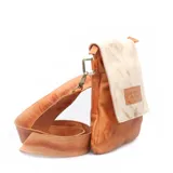 Morral pequeño de cuero con diseño bicolor, presentando una solapa superior en tono crema con efecto desgastado y cuerpo inferior en tono tostado. Incluye una correa larga ajustable y el logo de la marca grabado en un parche de cuero en la solapa.
