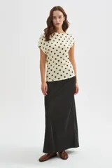 Top de poliéster color beige con estampado de lunares marrón oscuro, escote asimétrico y manga corta.