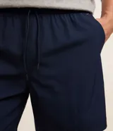 Bermuda masculina color beige, tipo boardshort, confeccionada en microfibra. Cuenta con cintura elástica, cordón ajustable y bolsillos.