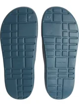 Ojotas tipo slide de color azul verdoso, con una banda ancha superior que presenta el logo 'CK' en relieve. La plantilla tiene textura acanalada para mayor agarre.