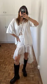 Pollera blanca de encaje con ruedo asimétrico, más corta adelante y larga atrás.