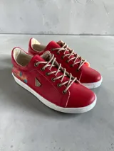 Championes de cuero rojo con detalles pintados a mano en el talón, suela blanca de goma y cordones beige.