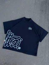 Remera negra oversize de manga corta con cuello redondo y estampa gráfica en color celeste en el pecho y el lateral inferior.
