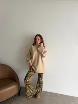 Pantalón tipo oxford de tiro alto, con estampado abstracto en tonos tierra, negro y crema. Presenta un corte ajustado en la parte superior y acampanado desde la rodilla hacia abajo.