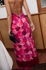 Vestido midi con estampado abstracto en tonos fucsia, rosa y violeta. Presenta un diseño de cuello halter cruzado con detalle de collar integrado y espalda descubierta.