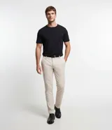 Pantalón slim de sastrería de color gris claro, confeccionado en sarga de algodón con elastano, con cierre frontal de botón y cremallera, y bolsillos.