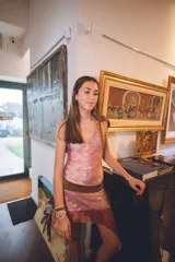 Vestido corto con estampado abstracto en tonos rosados, escote en V y breteles finos que se atan al cuello. Tiene corte en la cadera y falda con ruedo irregular y pico en lateral.