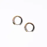 Par de aros tipo argolla gruesa, plateados con detalles dorados y tres incrustaciones de strass.