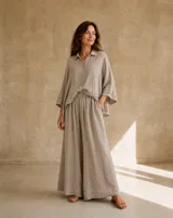 Pantalón ancho color beige de lino, con diseño de perneras holgadas y detalle de doble ruedo.